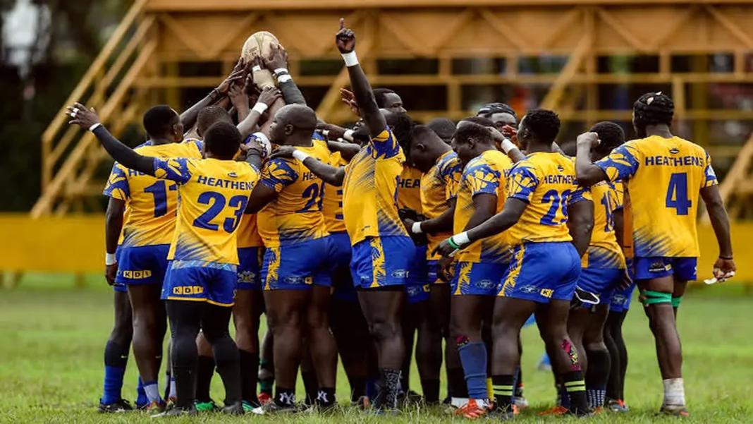 Heathens rugby players in yellow-and-blue kits huddle with a ball raised overhead.