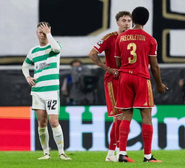Celtic player in green-and-white kits and LASK players in red kits stand on the pitch during a UEFA Champions League match