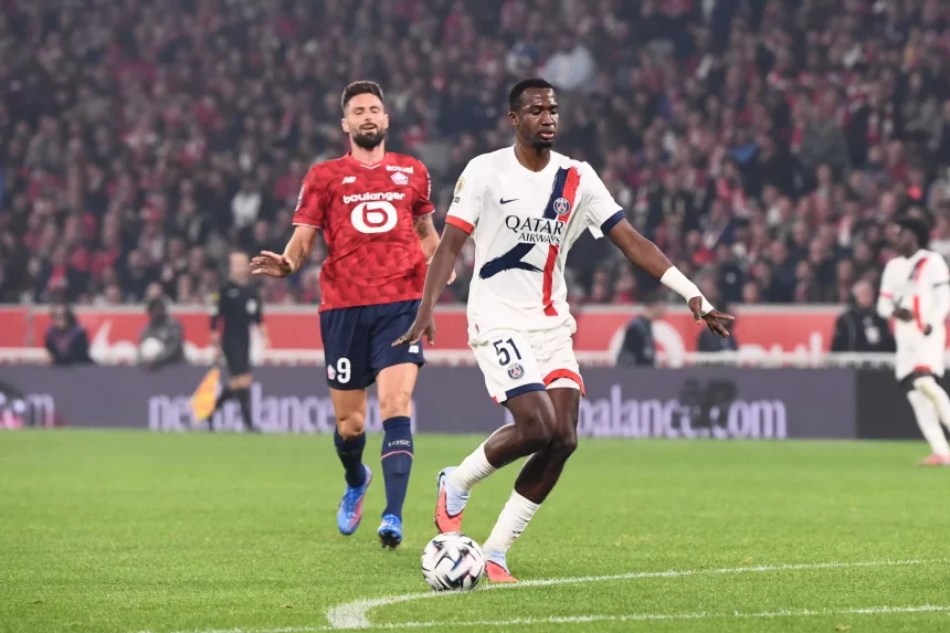Willian Pacho carries the ball as Olivier Giroud follows behind.