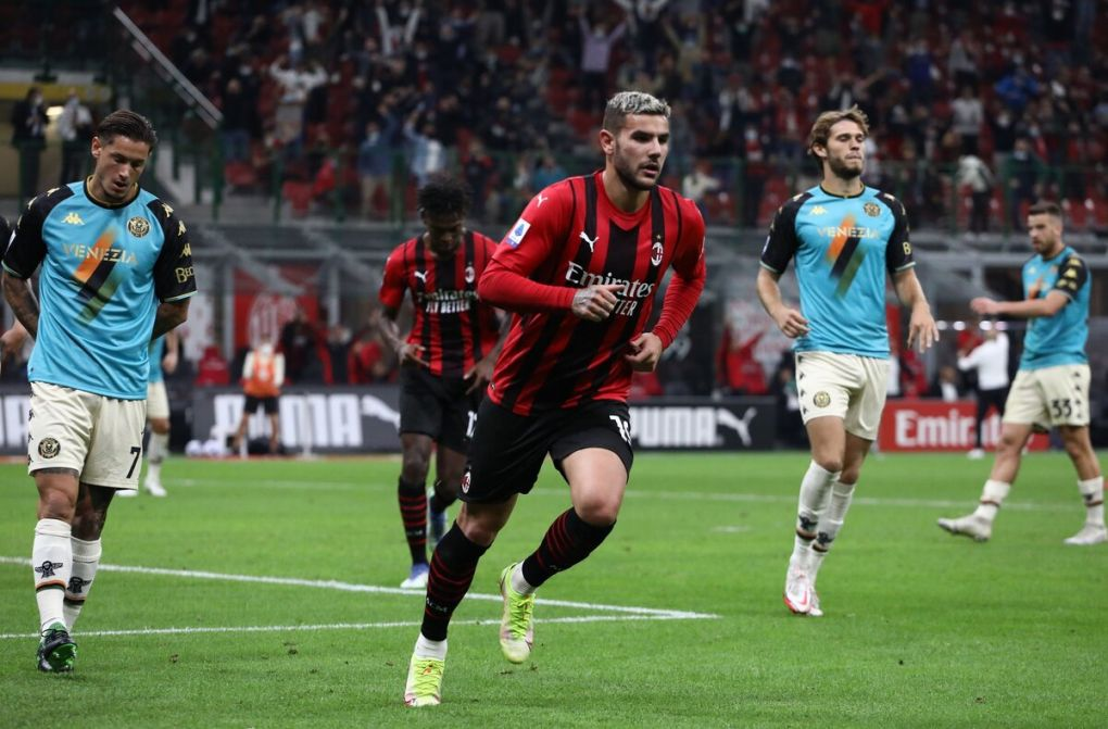 Theo Hernández in AC Milan colours runs between Venezia players at San Siro.