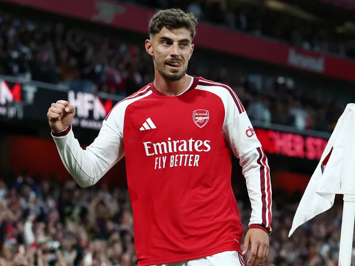 Arsenal forward Kai Havertz raises his fist while wearing the club’s red-and-white home jersey.