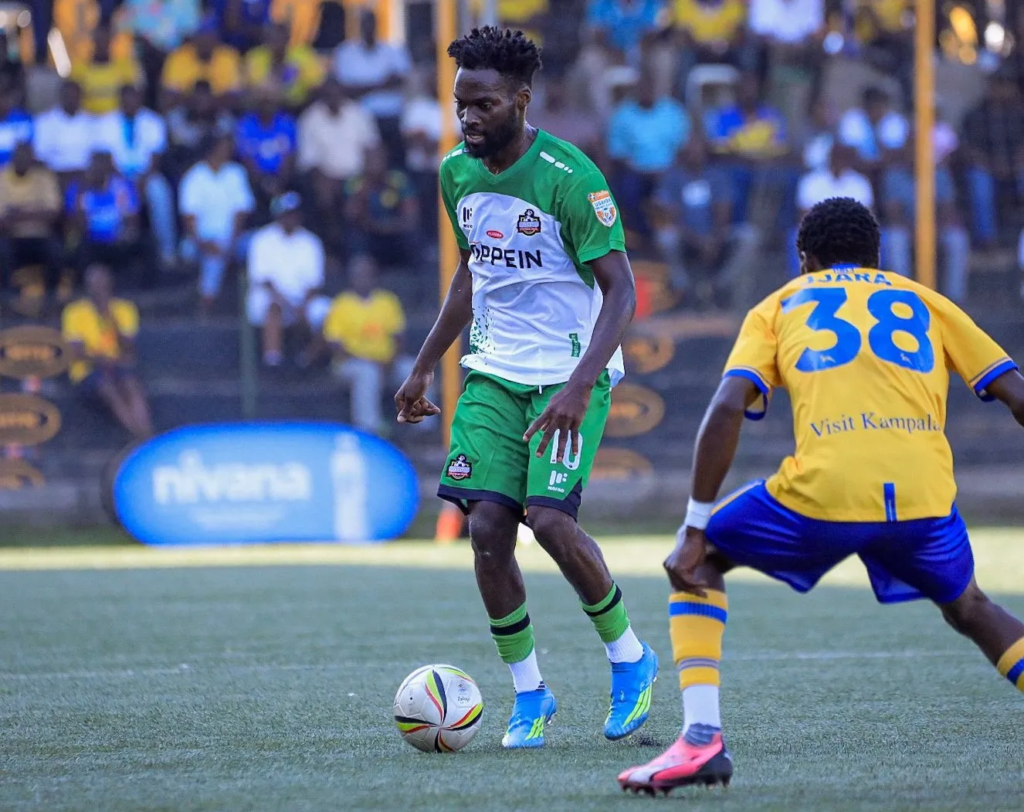 Allan Mugalu controls the ball for NEC while facing KCCA midfielder Brian Jjara.