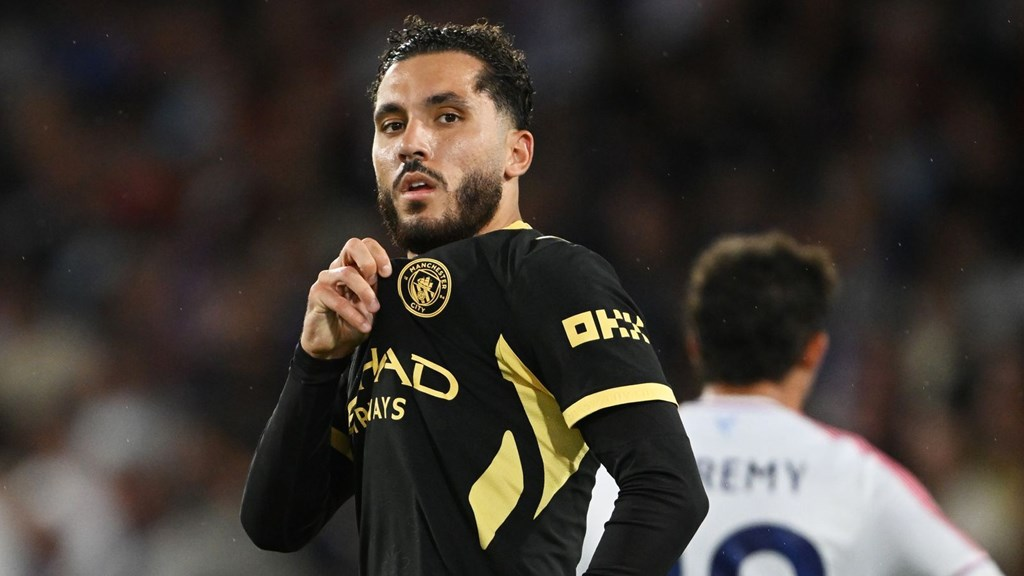 Manchester City midfielder Rayan Cherki holds the club badge on his shirt while celebrating against Crystal Palace.