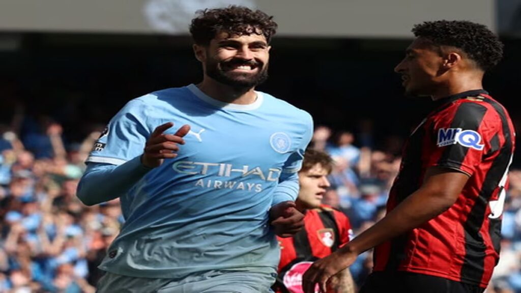 Manchester City defender Joško Gvardiol in a sky-blue kit runs on the pitch during a Premier League match against Bournemouth.