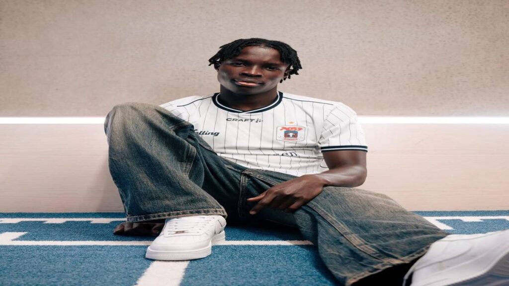 Elvis Torach sits on the floor wearing an AGF Aarhus shirt following his move from El Cambio Academy.