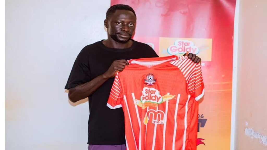 Bashir Asiku holds a Blacks Power jersey during his unveiling after completing his transfer to the Uganda Premier League club.