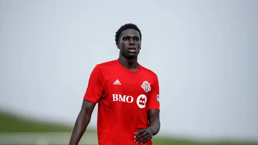 Midfielder Noble Okello Ayo pictured wearing a red Toronto FC jersey.