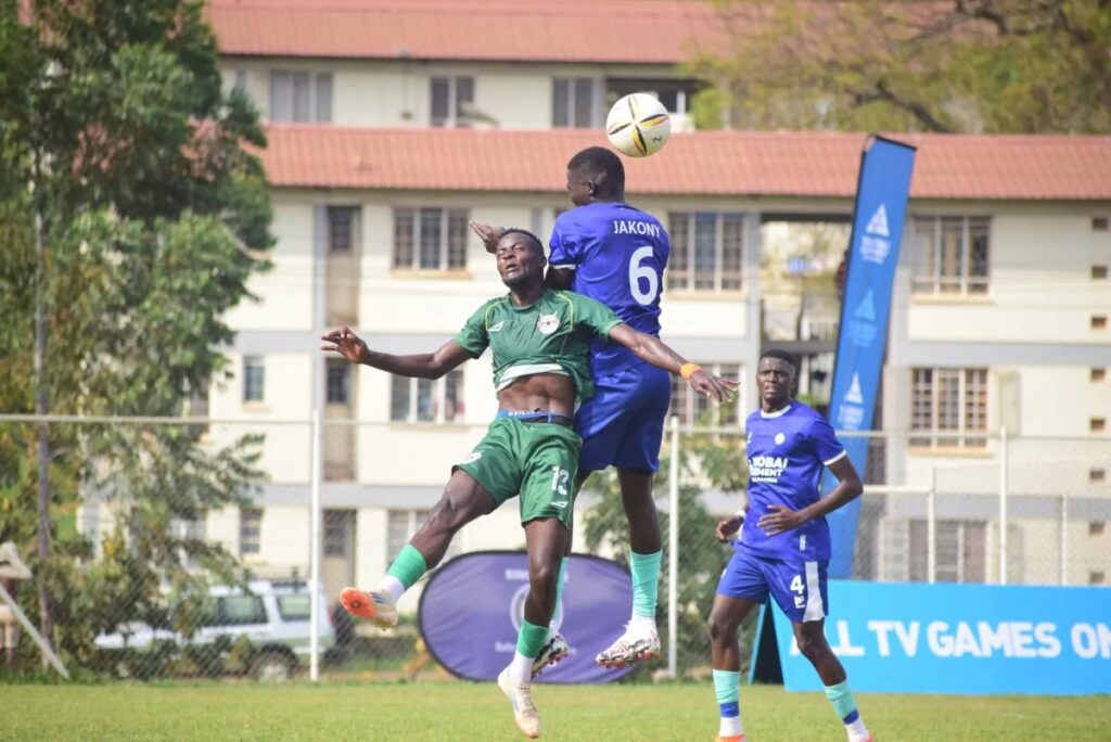 Green-shirted Derrick Taremwa and Police FC's Daniel Jakony (No.6) jump for a header during a Ugandan league match, with a fourth player watching on.