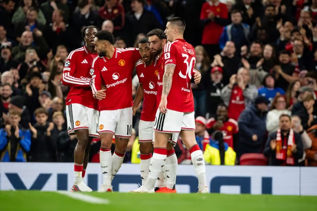 Manchester United players embrace in celebration in front of cheering fans during their Champions League match against Sabah.