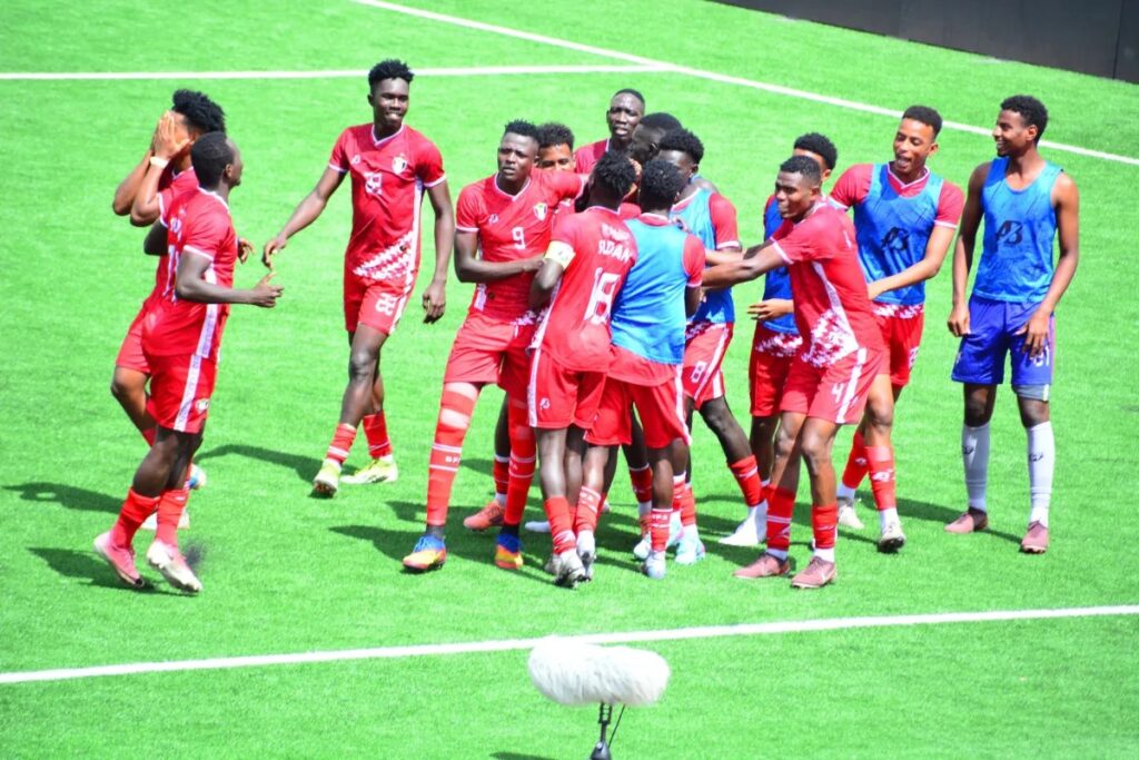 Sudan football players celebrating together on the pitch.