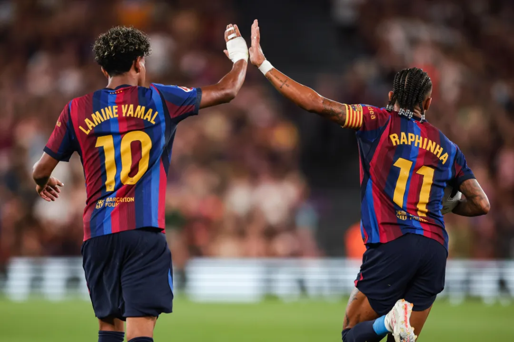 Barcelona forwards Lamine Yamal and Raphinha exchange a high-five during the La Liga win over Rayo Vallecano.