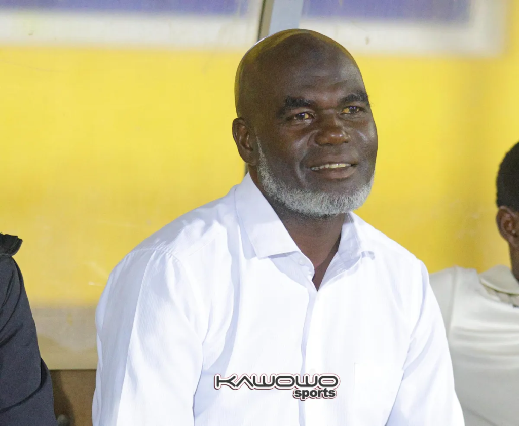 Portrait of NEC FC head coach Badru Kaddu Mukasa wearing a white shirt.