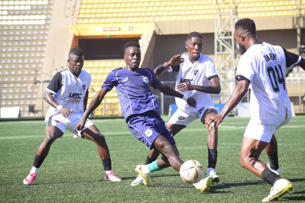 Entebbe UPPC player controls the ball under pressure from three UPDF players at Hamz Stadium.
