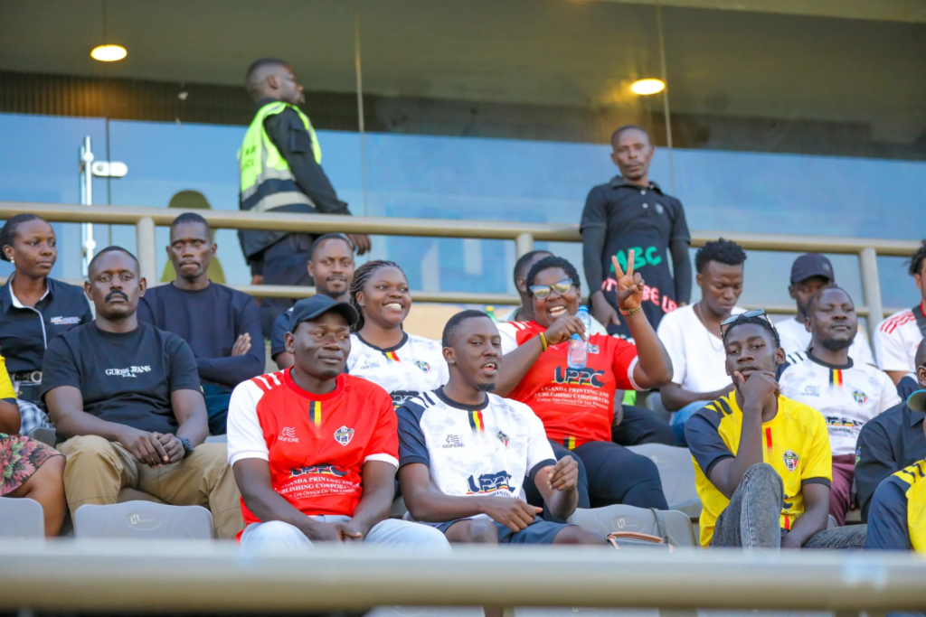Entebbe UPPC fans wearing the club’s red, white and yellow colours watch the match from the stands.