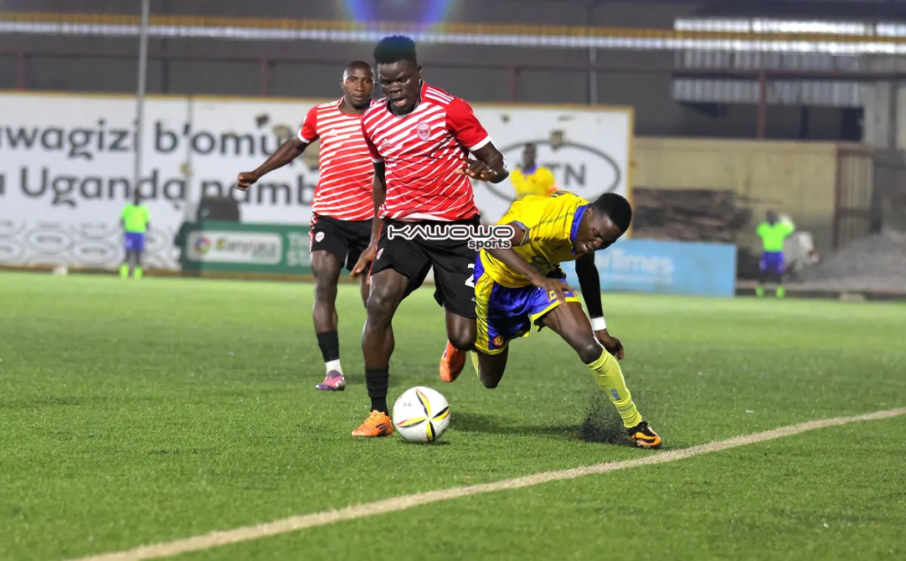 Express FC player shields the ball from a KCCA FC opponent during a Uganda Premier League match.