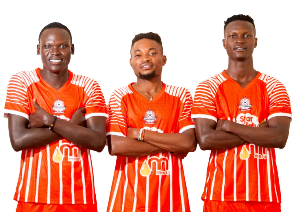Three Blacks Power players in orange home jerseys pose with their arms crossed.