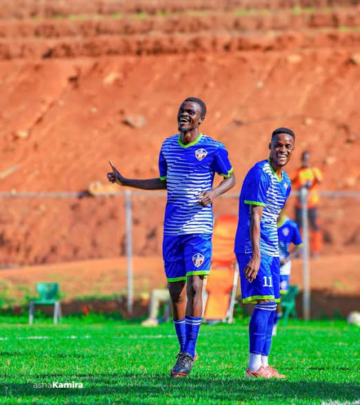 Two Maroons players in blue kits smile and gesture during a match.