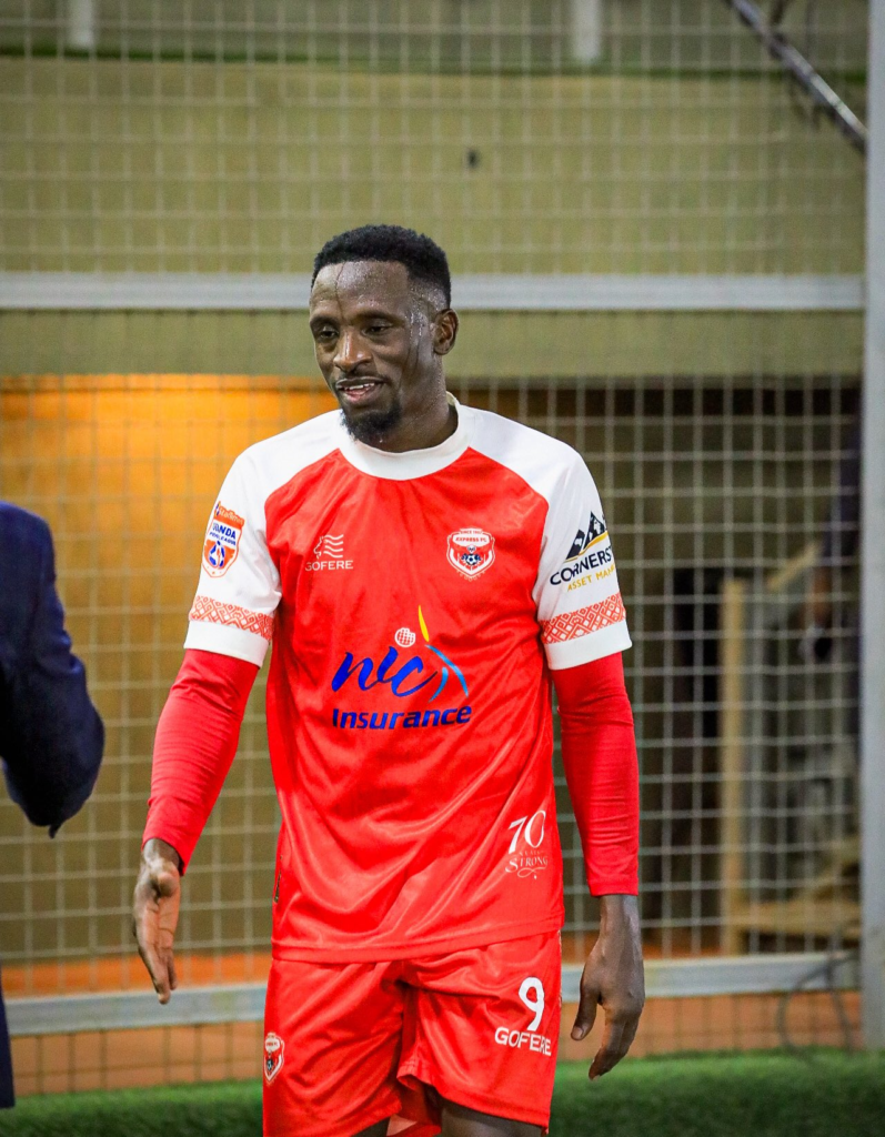 Derrick Ddungu Rickman walks on the pitch in an Express FC jersey during the match against KCCA FC.