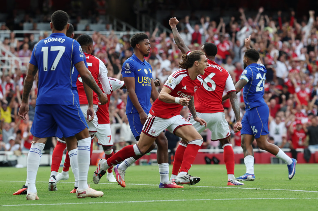 Arsenal players celebrate after finding the net against Chelsea, with Gabriel (6) and Riccardo Calafiori among those reacting as Chelsea's Rogers and Fofana look on dejected.