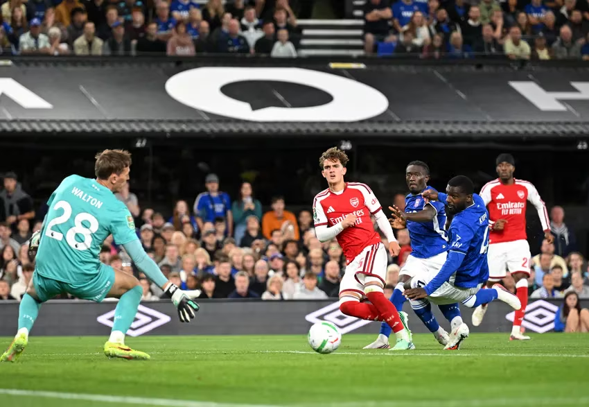Arsenal midfielder Max Dowman shoots towards Ipswich goalkeeper Christian Walton as two defenders attempt to block him.