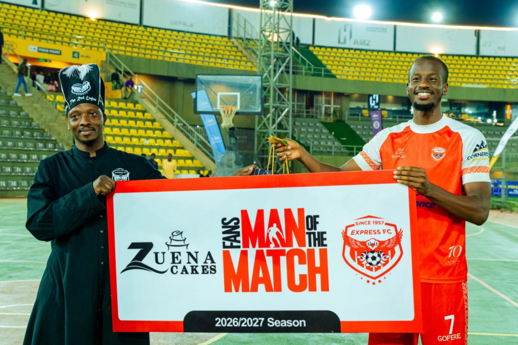 Alpha Thierry Ssali smiles while receiving Express FC’s Fans’ Man of the Match award from a Zuena Kirema Cakes representative at Hamz Stadium.