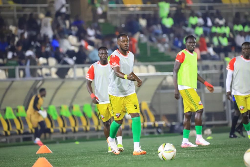 Kitara FC players wearing training bibs warm up with footballs on the pitch before facing Express FC at Hamz Stadium.