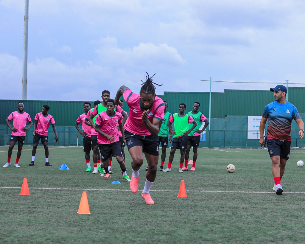 Vipers SC players and a coach conducting sprint drills with cones during a team training session.