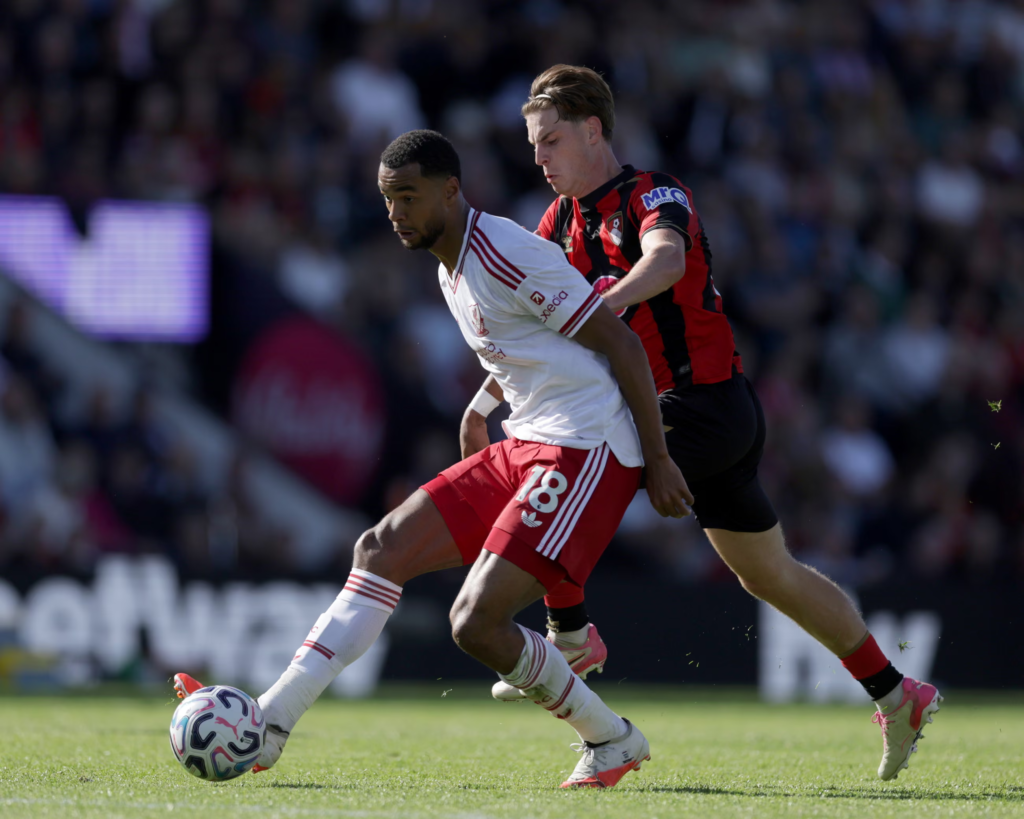 Liverpool player Cody Gakpo in action, challenging for the ball with Scott.
