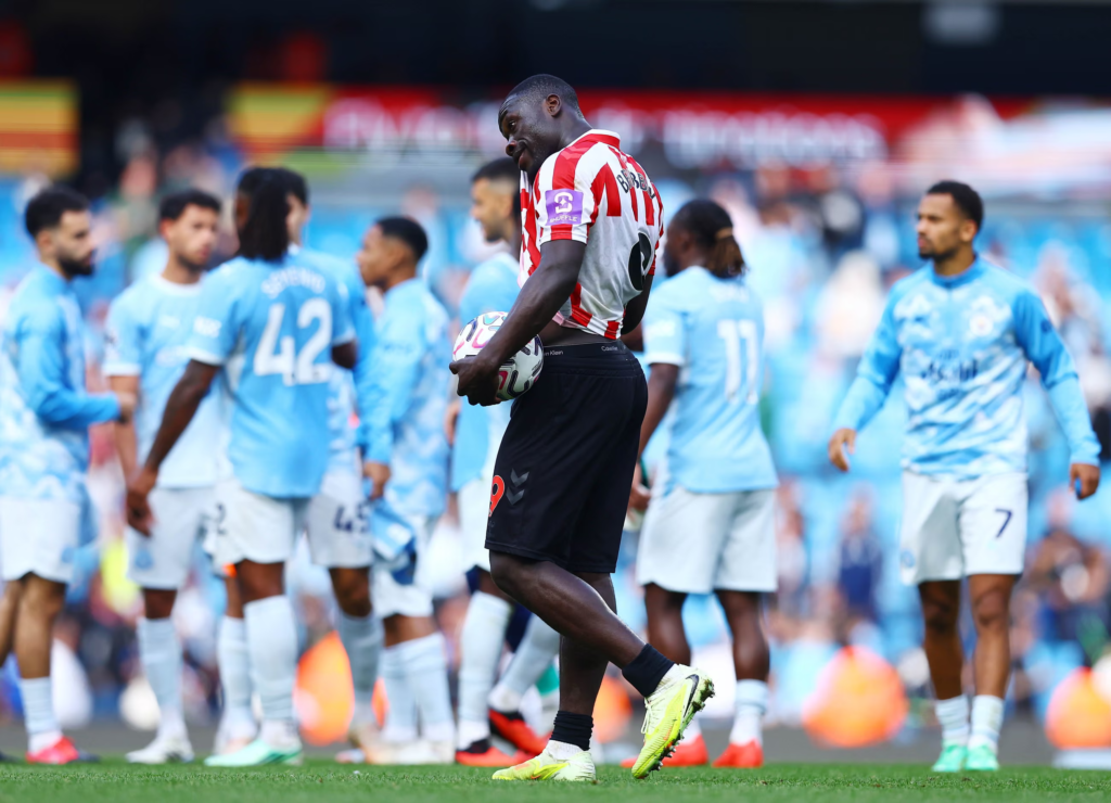 Sunderland striker Brian Brobbey holding the match ball but looking dejected following his team's defeat.