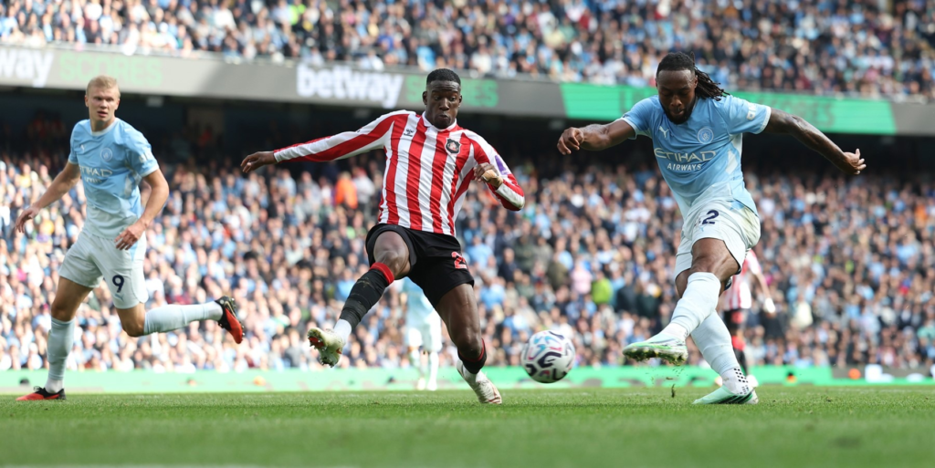 A player named Semenyo striking the ball during a match.