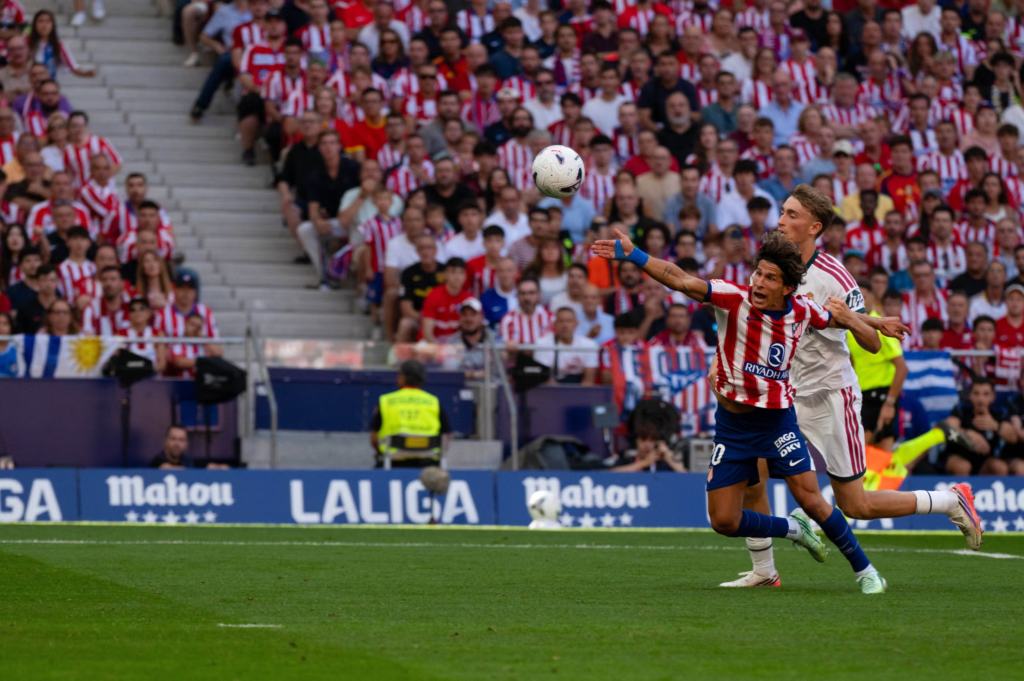 Real Madrid defender Dean Huijsen fouling Giuliano Simeone in the penalty area, resulting in a penalty and his own red card.