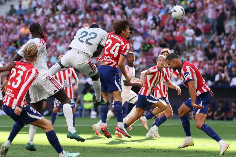 Real Madrid player Antonio Rüdiger scoring a goal with a header.