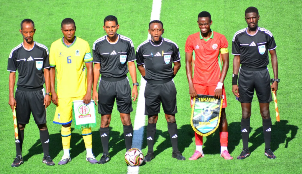 The captains of Tanzania U-20 and Burundi U-20 posing with match officials before kickoff.