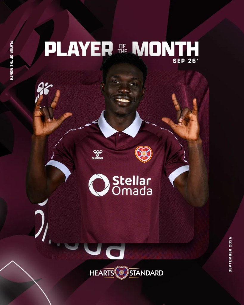 Uganda Cranes and Hearts of Midlothian player Rogers Mato in a maroon home kit smiling and making rock-hand gestures, on a "Player of the Month, Sep 26" graphic with sponsor Stellar Omada.