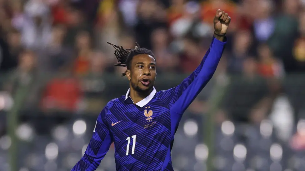 France forward Michael Olise, wearing No. 11, celebrating with a raised fist after scoring the winning goal against Belgium.
