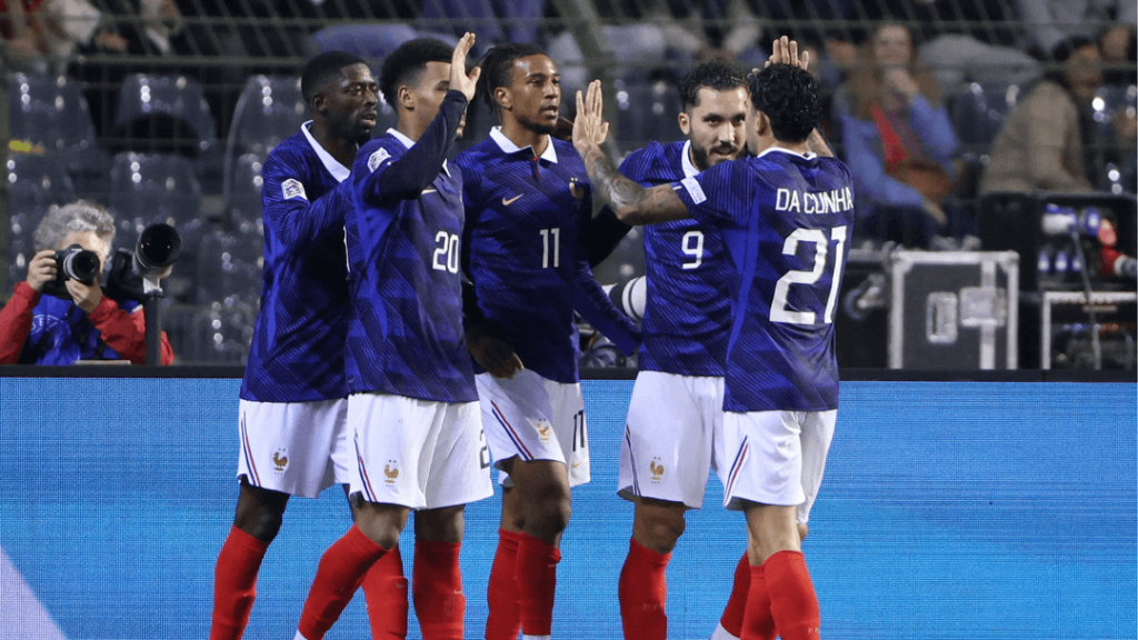 France players high-fiving each other in celebration, including No. 11 Olise, No. 9, and No. 21 Da Cunha, after scoring against Belgium.