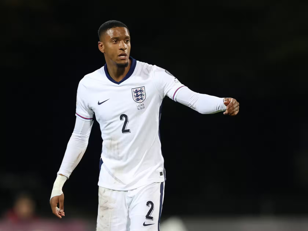 England player wearing No. 2, in a muddy kit, gesturing and directing play during the match