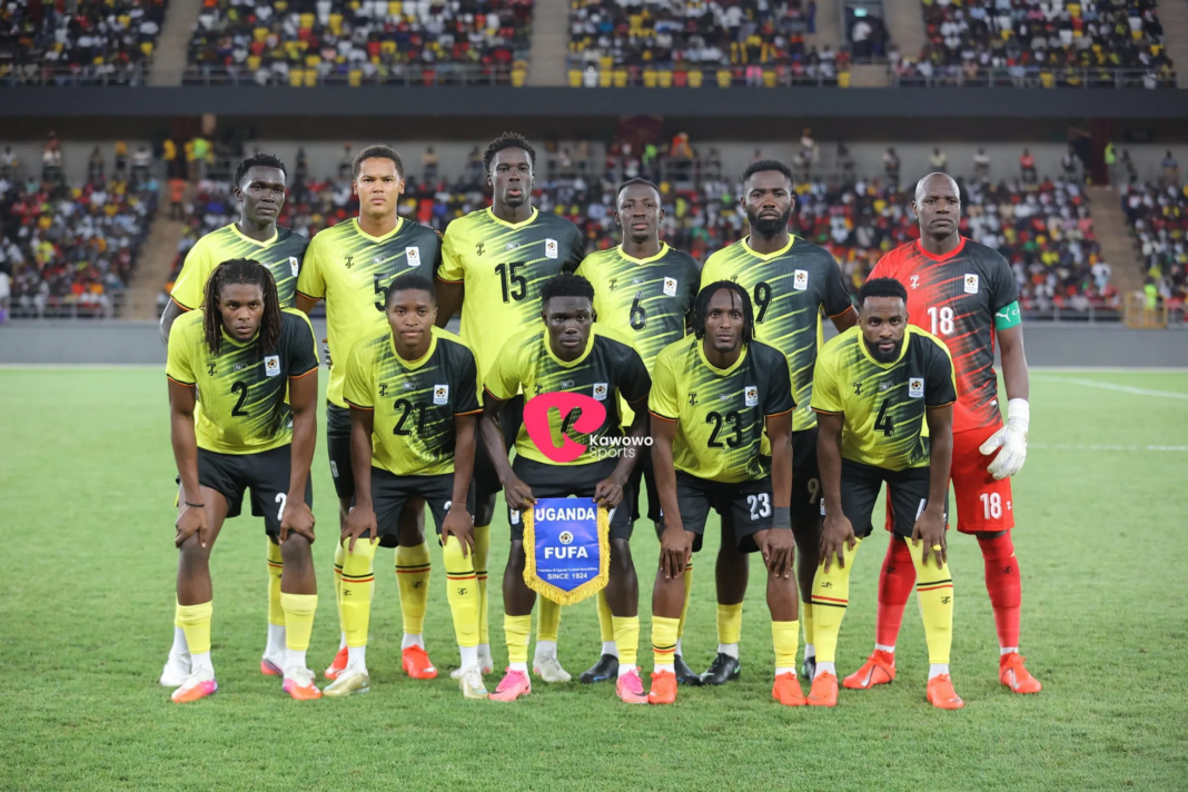 The Uganda Cranes starting XI posing for a team photo before their match against Libya, with a player holding a 