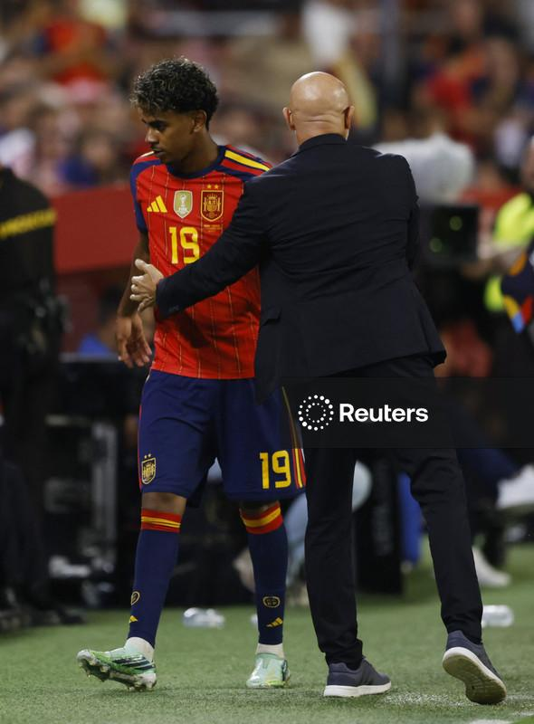 : Lamine Yamal speaks with Spain coach Luis de la Fuente after being substituted in Seville.