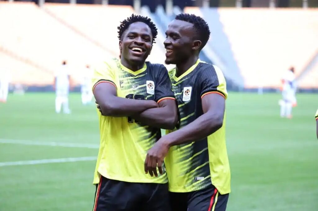 ganda Cranes players James Bogere and Mukundane smiling and embracing in celebration.