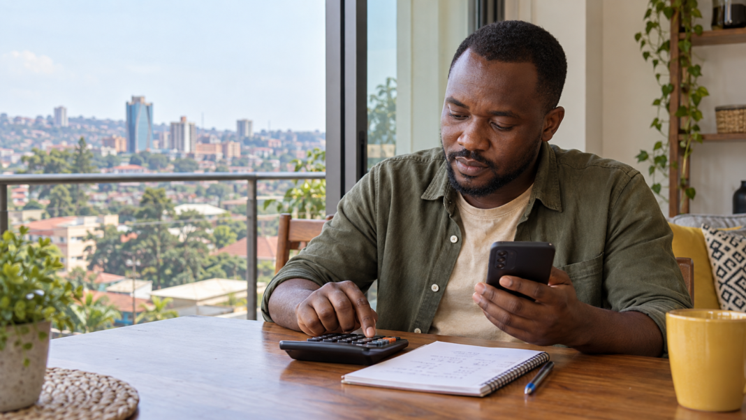 Adult Ugandan checks Aviator payout using phone calculator.