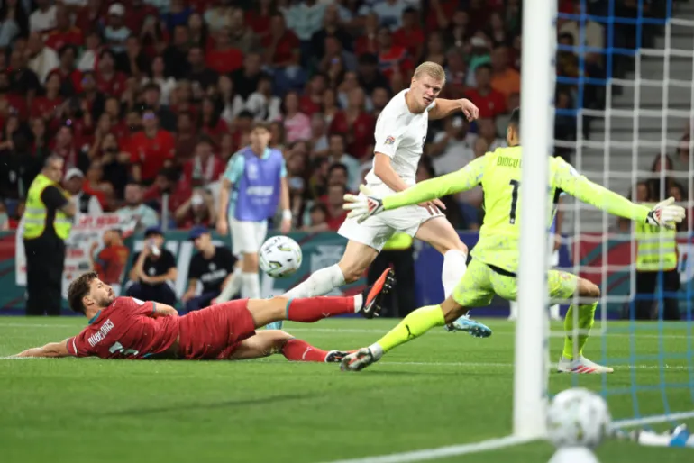 Norway forward Erling Haaland, centre, striking the ball across the goalmouth.