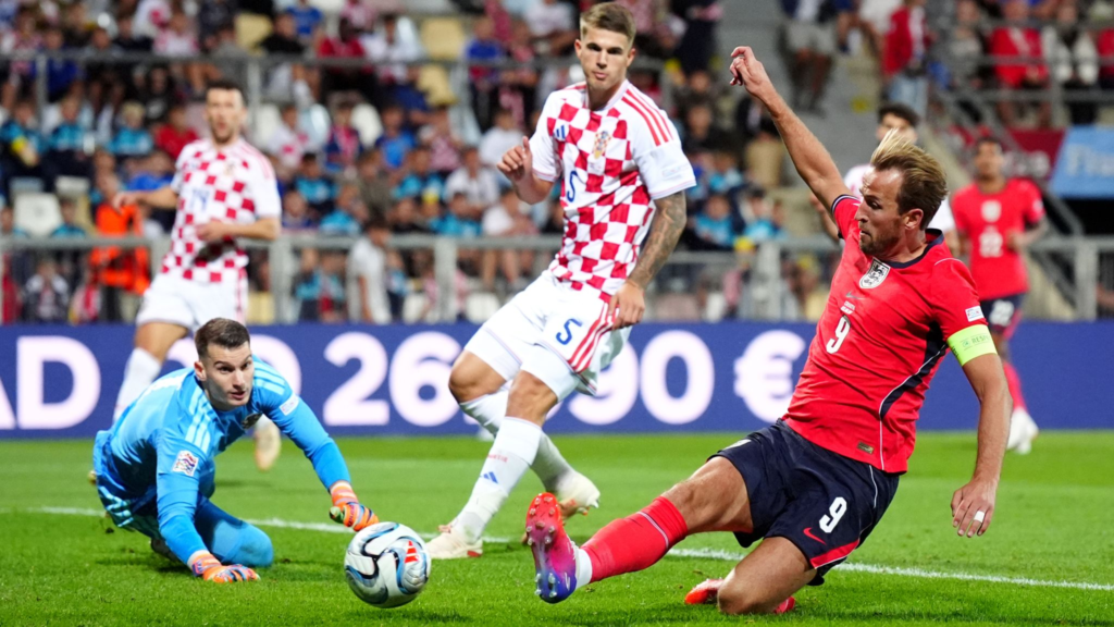 England forward Harry Kane sliding in to score his side's fifth goal against Croatia.