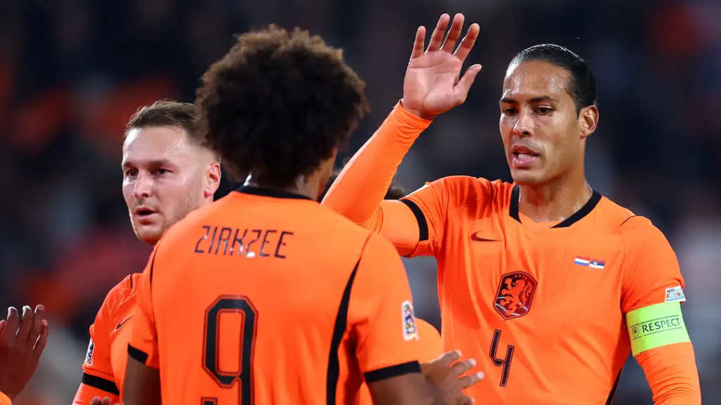 Netherlands forward Joshua Zirkzee celebrating with captain Virgil van Dijk and a teammate after scoring against Serbia.