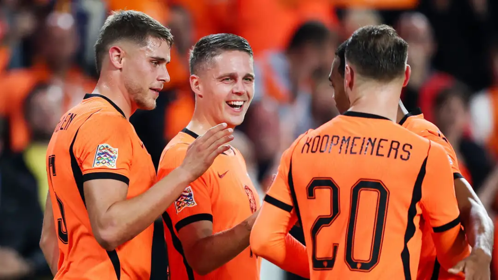Netherlands players, including Teun Koopmeiners wearing No. 20, celebrating and smiling together during a match.