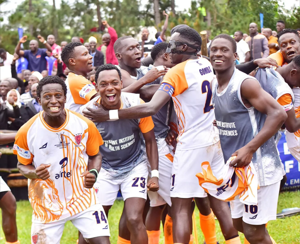 Gomba Ssaza football players celebrating together on the pitch.