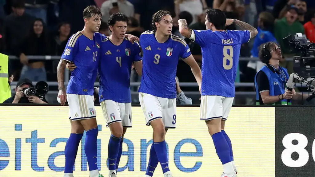 Italy players, including No. 17, No. 4, No. 9 Francesco Pio Esposito, and No. 8 Sandro Tonali, celebrating together on the pitch.