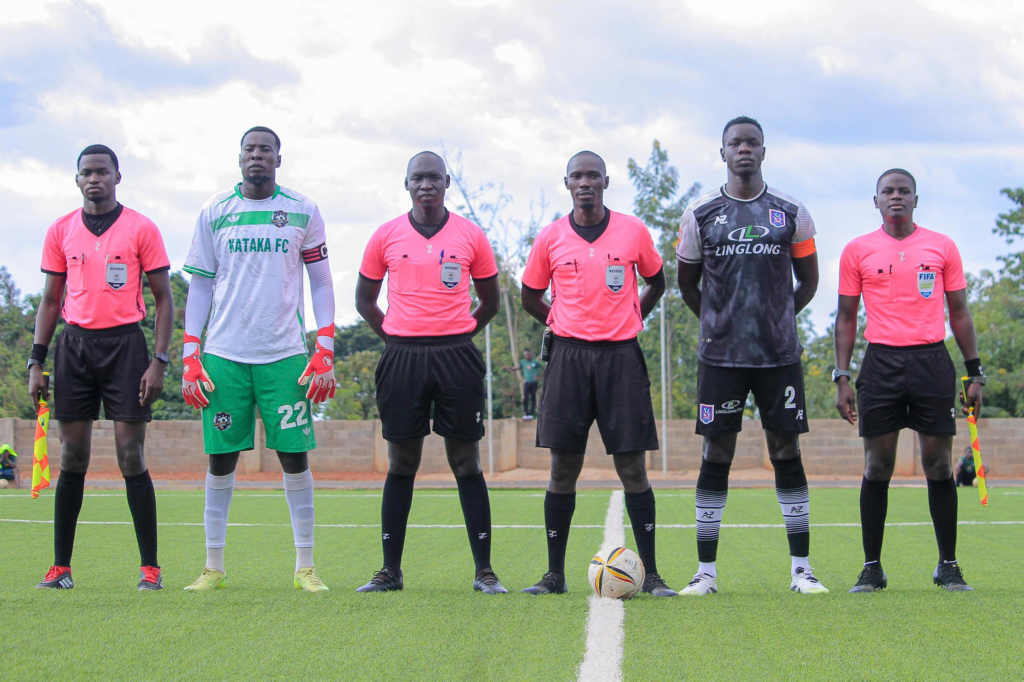 Kataka and Villa captains stand beside match officials.