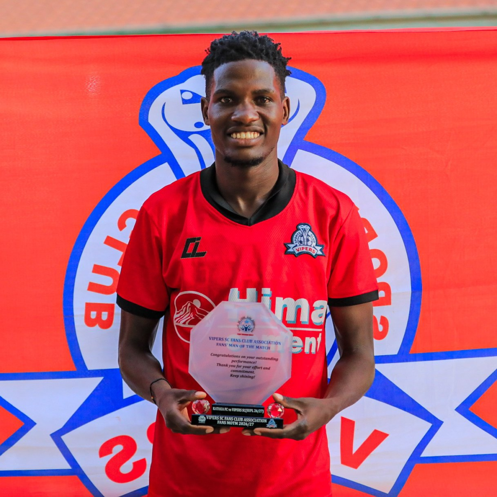 Vipers SC player Usama Arafat, in a red Vipers kit, smiling and holding a clear octagonal “Fans’ Man of the Match” trophy from the Vipers SC Fans Club Association, in front of a red Vipers SC banner with the club’s cobra crest.