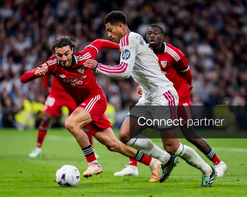 Jude Bellingham carries the ball against Sevilla players.